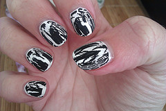 manicured hand with black and white crackle nail polish