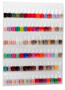Clear acrylic nail polish rack hanging on the wall filled with bottles
