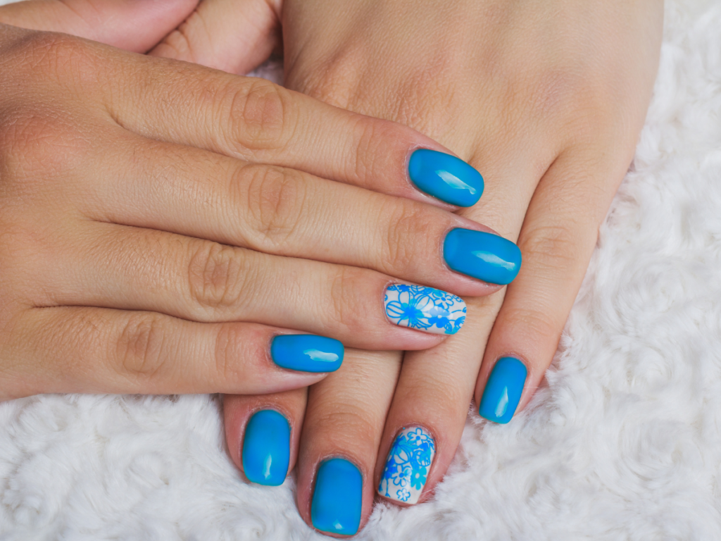 Blue nails with one accent nail with white polish and blue flowers