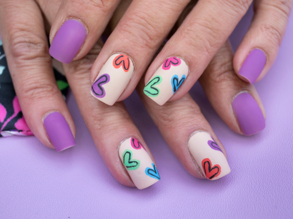 Pastel Valentine's nails with purple polish and nude polish and hearts